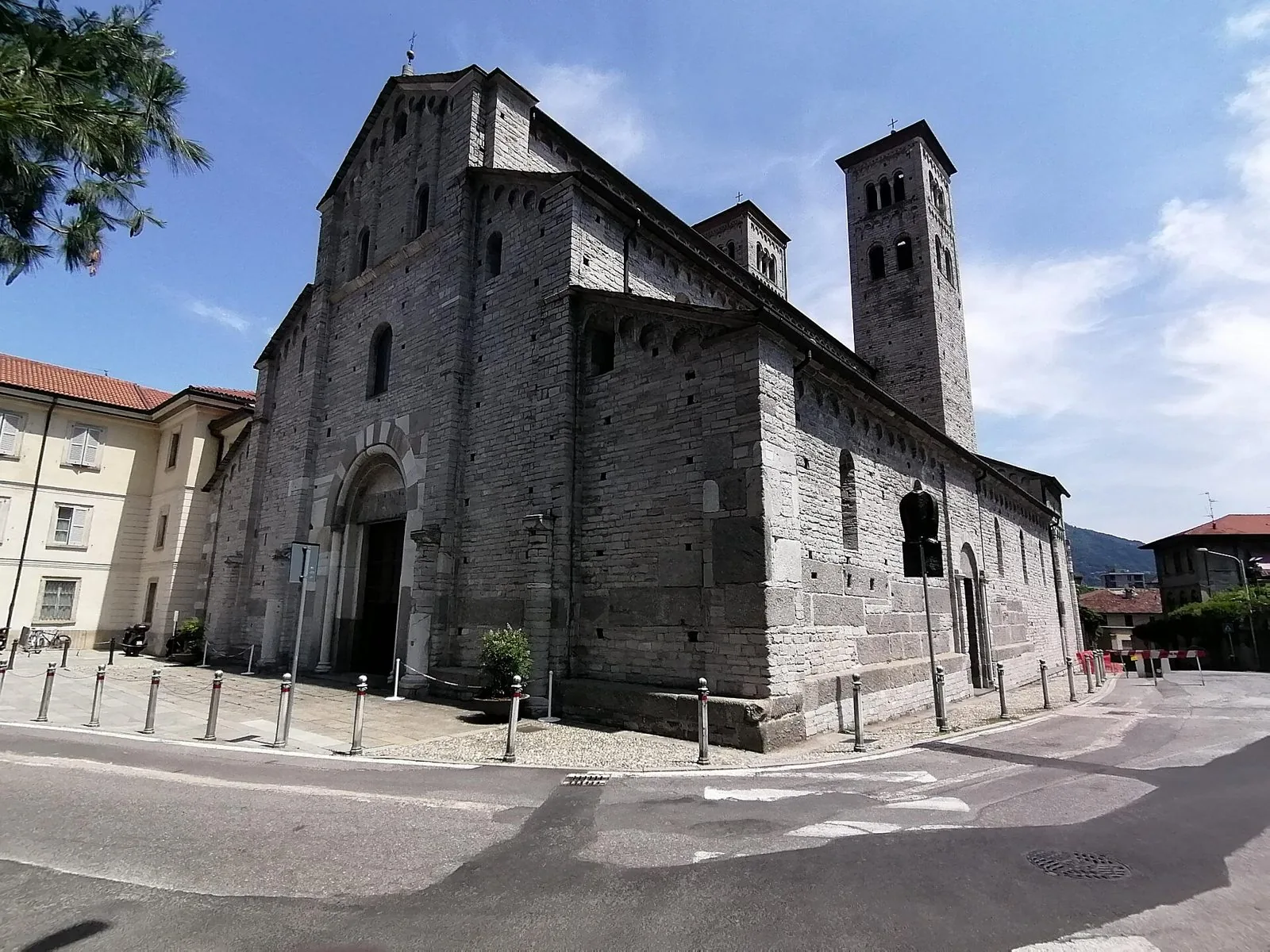 La Basilica romanica di Sant'Abbondio a Como, in pietra grigia, con il portale ad arco e uno dei due campanili gemelli